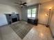 Cozy living room featuring a stone fireplace, neutral tile flooring, and bright window at 890 Emerald Dr, Mount Dora, FL 32757