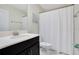 Clean bathroom featuring a single vanity, white tile floors, and a shower with white curtain at 9034 Stinger Dr, Davenport, FL 33896
