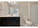 This bathroom includes a toilet, walk-in shower, vanity with sink, modern mirror, and bright, neutral decor at 9034 Stinger Dr, Davenport, FL 33896