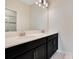 This bathroom has double sinks, a large mirror, modern lighting, and sleek dark cabinetry providing ample storage at 9034 Stinger Dr, Davenport, FL 33896