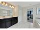 Bright bathroom features double sinks, a large mirror, and a view to a well-decorated bedroom at 9034 Stinger Dr, Davenport, FL 33896
