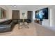 This game room features a large leather sofa, a modern television, and plush carpeting for ultimate comfort at 9034 Stinger Dr, Davenport, FL 33896