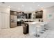 Modern kitchen boasts stainless appliances, dark cabinetry, stylish island with barstool seating, and bright recessed lighting at 9034 Stinger Dr, Davenport, FL 33896