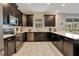 This kitchen features stainless steel appliances, dark cabinets, white subway tile backsplash, and elegant countertops at 9034 Stinger Dr, Davenport, FL 33896