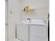 Functional laundry room featuring a washer, a dryer, and a wire shelf for storage at 9034 Stinger Dr, Davenport, FL 33896