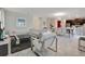 Spacious living room flowing into dining area features modern decor, white tile floors, and ample natural light at 9034 Stinger Dr, Davenport, FL 33896