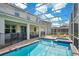 Screened-in pool and spa surrounded by a brick patio and a covered seating area at 9034 Stinger Dr, Davenport, FL 33896