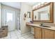 Bathroom vanity with wood cabinets, large mirror, and walk-in shower area at 10585 Sw 38Th Ave, Ocala, FL 34476