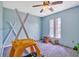 Bright bedroom with blue walls and carpet featuring a window and toys at 10585 Sw 38Th Ave, Ocala, FL 34476