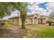 View of the house highlighting the chimney, stucco exterior, covered entry and green lawn at 10585 Sw 38Th Ave, Ocala, FL 34476