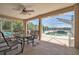 Covered patio with ceiling fan and outdoor seating, leading to screened pool area at 10585 Sw 38Th Ave, Ocala, FL 34476