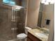 Well-lit bathroom with a glass enclosed shower, granite countertop, and single sink vanity at 11120 Se 168Th Loop, Summerfield, FL 34491