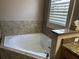 Bright bathroom featuring a soaking tub with tiled surround and granite countertop at 11120 Se 168Th Loop, Summerfield, FL 34491