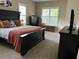 Comfortable bedroom featuring a large bed, window shutters, and dark wood furniture at 11120 Se 168Th Loop, Summerfield, FL 34491