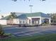 Exterior view of building with a green roof, palm trees, and a parking lot at 11120 Se 168Th Loop, Summerfield, FL 34491