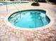 Inviting hot tub nestled amidst a brick patio, providing a tranquil space for relaxation at 11120 Se 168Th Loop, Summerfield, FL 34491
