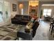 Living room featuring a large brown leather couch, neutral walls, and access to a bar at 11120 Se 168Th Loop, Summerfield, FL 34491