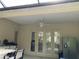 Outdoor patio boasts a ceiling fan, bar area, and access to the home through elegant glass doors at 11120 Se 168Th Loop, Summerfield, FL 34491