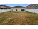 Private backyard with a well-maintained lawn, enclosed by a white fence and sliding glass doors at 1123 Hacienda Cir, Kissimmee, FL 34741