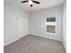 A bright bedroom with soft gray carpet, a ceiling fan, and a window with natural light at 1123 Hacienda Cir, Kissimmee, FL 34741