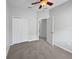 Bedroom featuring soft gray carpet, a ceiling fan, large closet, and an open doorway to the hall at 1123 Hacienda Cir, Kissimmee, FL 34741