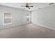 A bright bedroom with soft gray carpet and two windows with natural light at 1123 Hacienda Cir, Kissimmee, FL 34741