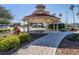 The gazebo is surrounded by paved walkway, various plants and lawn at 1219 Normandy Dr, Haines City, FL 33844