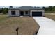 Charming single-story home with a well-manicured lawn and a paved driveway leading to an attached garage at 13253 Sw 83Rd Cir, Ocala, FL 34473