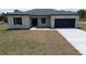 Inviting single-story home featuring a minimalist design, complemented by fresh landscaping and a concrete driveway at 13253 Sw 83Rd Cir, Ocala, FL 34473