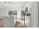 Modern kitchen boasts stainless steel appliances, white cabinetry, quartz countertops, and stylish pendant lighting at 13253 Sw 83Rd Cir, Ocala, FL 34473