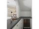 View of the kitchen from the bar featuring a built in wine refrigerator and white cabinets at 1400 Place Picardy, Winter Park, FL 32789