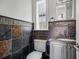 Stylish powder room with unique tilework, a marble countertop sink, and a decorative mirror at 1400 Place Picardy, Winter Park, FL 32789