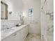 Bright bathroom with marble walls, double vanity, and marble tile flooring at 1400 Place Picardy, Winter Park, FL 32789