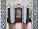 Elegant foyer with dark wood floors, statement lighting, and blue patterned accent walls at 1400 Place Picardy, Winter Park, FL 32789