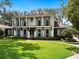 Elegant home featuring an expansive lawn, a second-story balcony, and contrasting light blue shutters for a stylish look at 1400 Place Picardy, Winter Park, FL 32789