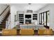 Bright living room with sleek white sofa, decorative fireplace, and dark hardwood floors, exuding a modern elegance at 1400 Place Picardy, Winter Park, FL 32789