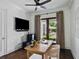 Office features a modern desk, ceiling fan, and french doors leading to patio at 1400 Place Picardy, Winter Park, FL 32789
