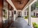 Long covered patio with dark ceiling, ceiling fans and views of the manicured lawn at 1400 Place Picardy, Winter Park, FL 32789