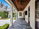 Covered patio with dark wood ceiling, ceiling fans, and views of the manicured lawn at 1400 Place Picardy, Winter Park, FL 32789