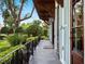 Charming porch with iron railing, blue shutters, and lush landscaping, providing a serene outdoor space at 1400 Place Picardy, Winter Park, FL 32789