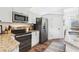 This kitchen features white cabinets and stainless steel appliances with wooden floors and granite counters at 1578 Farrindon Cir # 1578, Lake Mary, FL 32746