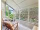 Relax in this sunroom filled with plants and windows with comfortable seating at 1578 Farrindon Cir # 1578, Lake Mary, FL 32746