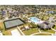 Aerial view of community amenities including pool, tennis court, clubhouse and manicured landscaping near residential homes at 16054 Johns Lake Overlook Dr, Winter Garden, FL 34787