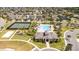 Aerial view of a community clubhouse and pool with tennis courts and homes in the background at 16054 Johns Lake Overlook Dr, Winter Garden, FL 34787