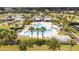 Aerial view of community clubhouse and pool surrounded by lush landscaping and shaded seating areas at 16054 Johns Lake Overlook Dr, Winter Garden, FL 34787