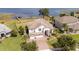 Beautiful aerial view of landscaped home with dock on the water and manicured lawn at 16054 Johns Lake Overlook Dr, Winter Garden, FL 34787