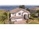 Stunning aerial view of a two-story home with a three-car garage that is located on the water at 16054 Johns Lake Overlook Dr, Winter Garden, FL 34787