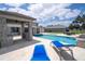 Luxurious backyard featuring a pool, spa, outdoor kitchen, and stunning lake views at 16054 Johns Lake Overlook Dr, Winter Garden, FL 34787