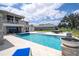 Expansive backyard with a pool, spa, covered patio, and breathtaking views of the lake at 16054 Johns Lake Overlook Dr, Winter Garden, FL 34787