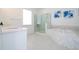 Enjoy the tub and shower in this stylish bathroom, which is complete with white tile and sleek fixtures at 16054 Johns Lake Overlook Dr, Winter Garden, FL 34787
